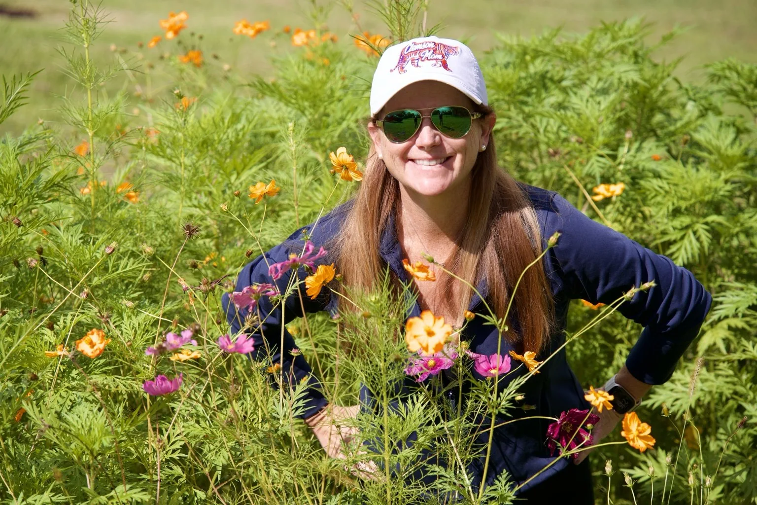 Angele smiling among the farm's summer wildflowers
